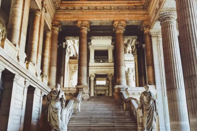 Stone staircase surrounded by columns and statues. Photo.