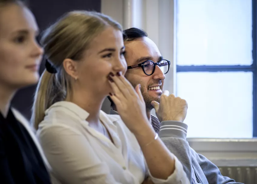 Three students listening at a seminar. Photo.